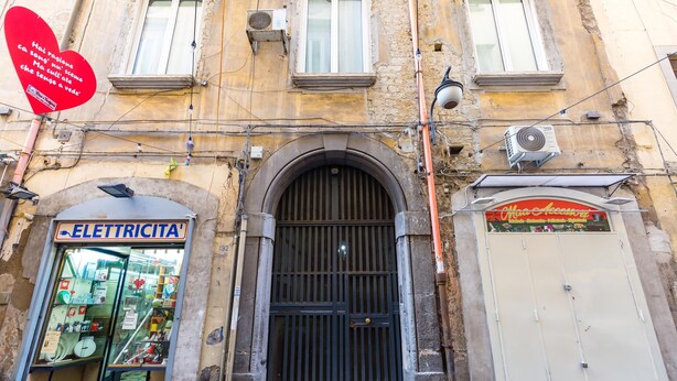 Un bâtiment dont la devanture porte l’inscription « ELETTRICITA » et dont la porte est fermée.