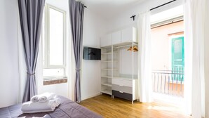 Une chambre à coucher avec un lit, une armoire et un balcon offrant une vue.