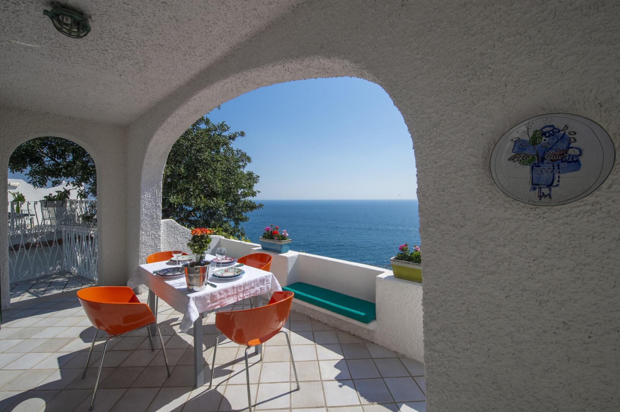 A terrace with a table set for two, overlooking the sea.