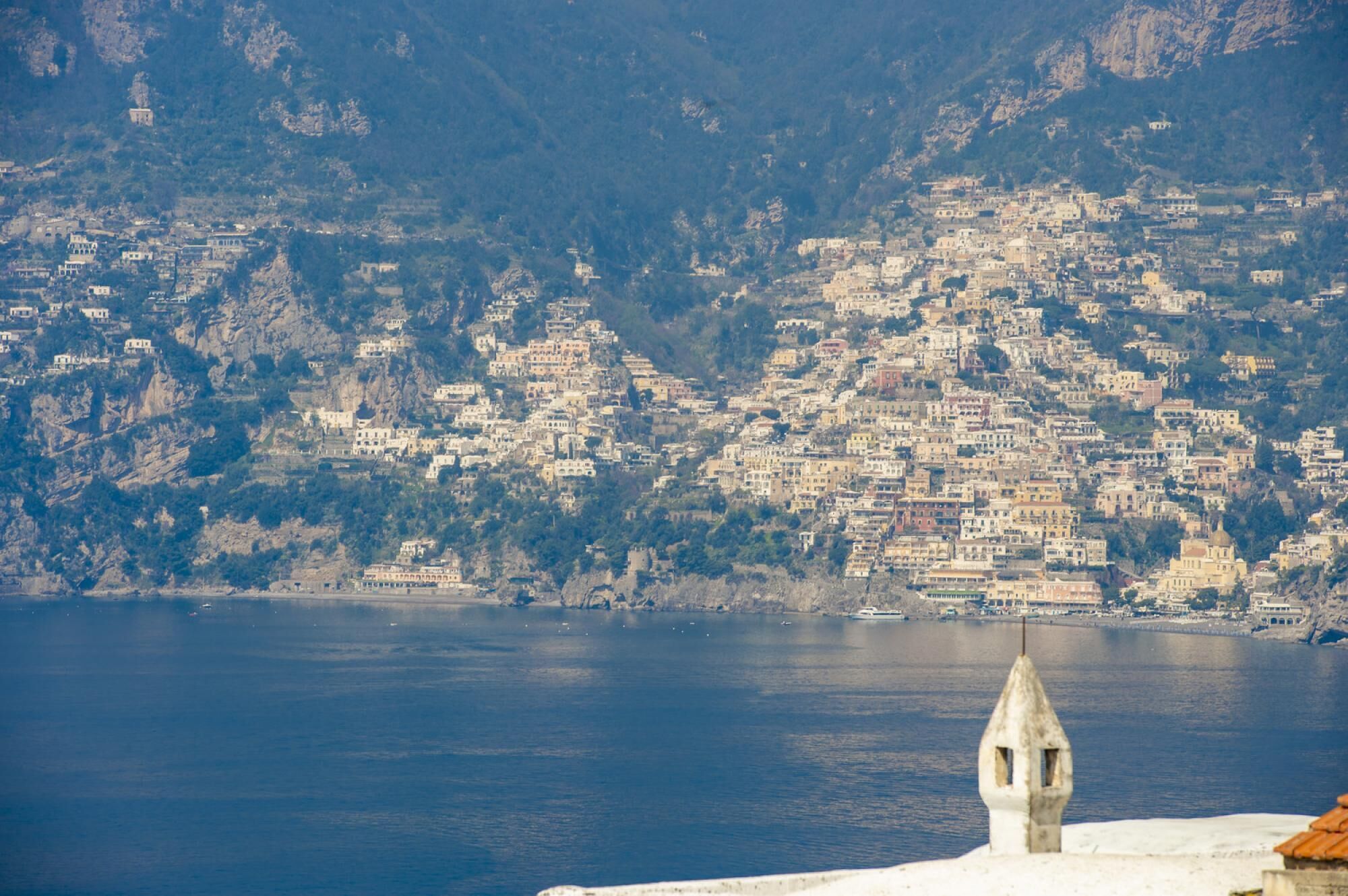 A coastal town with buildings built on a hillside overlooking the sea.