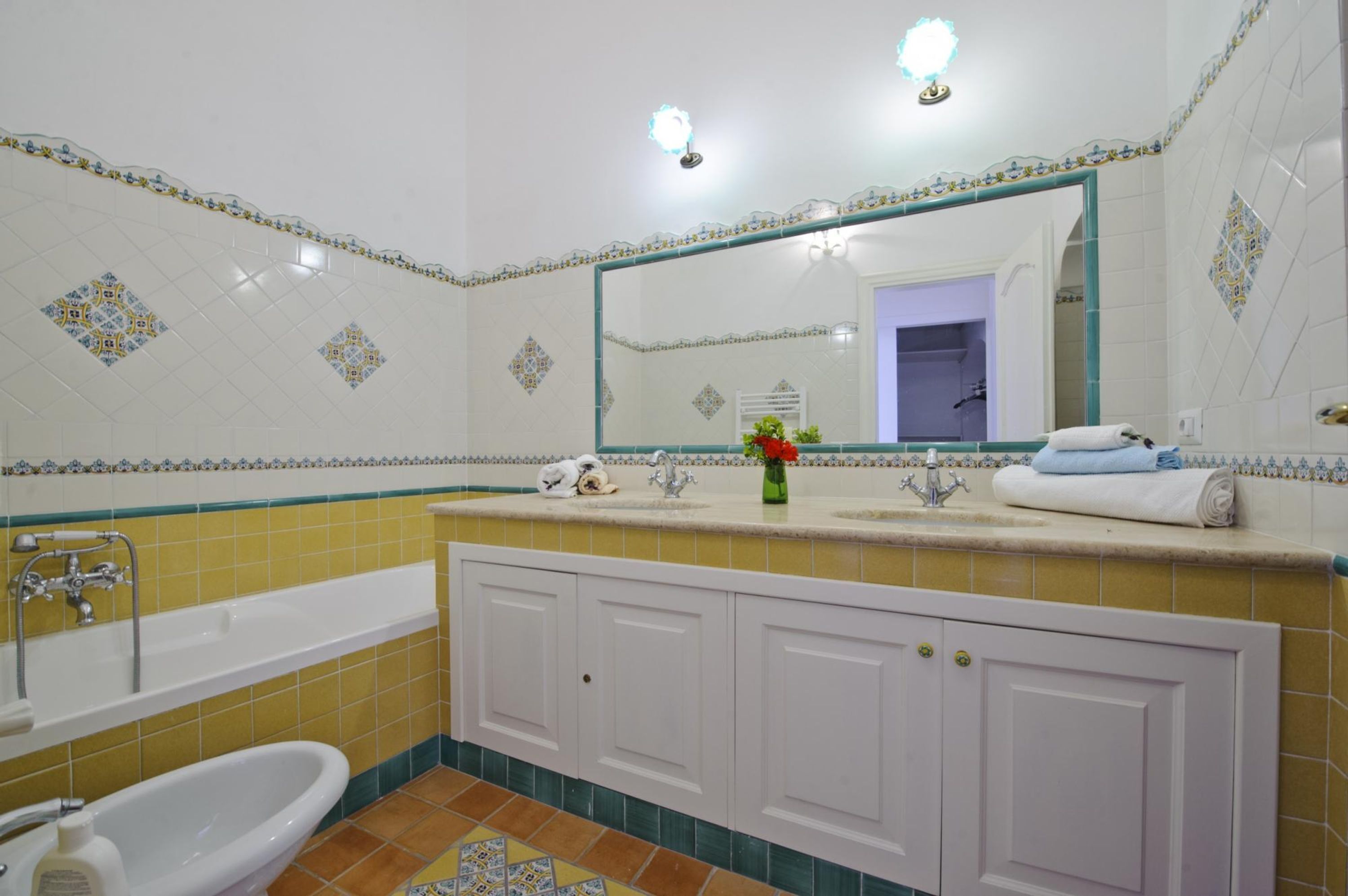 A bathroom with a bathtub, sink, and mirror.