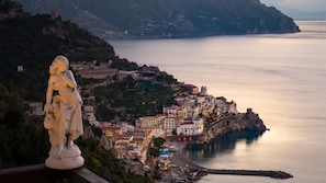 A coastal town with a statue on a cliff overlooking the sea.