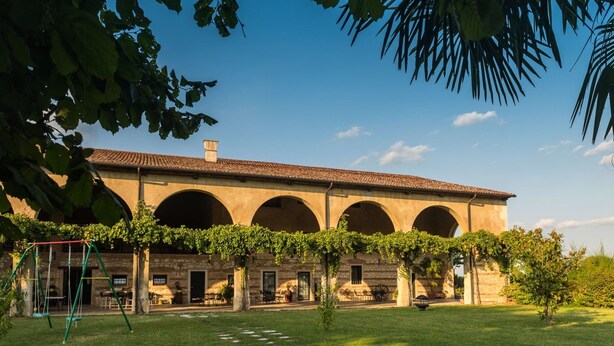 A building with a courtyard, stone arches, and a pergola with vines. - Rosmarino Apartment With two Bedrooms and one Bathroom on the Ground Floor Apartment 1 (Longare)