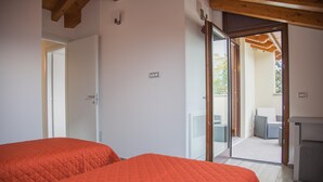 A bedroom with two beds, a sliding glass door leading to an outdoor area with furniture. - C0-e569-lbag97a2 - Dream Lake Apartment 1 (Lezzeno)