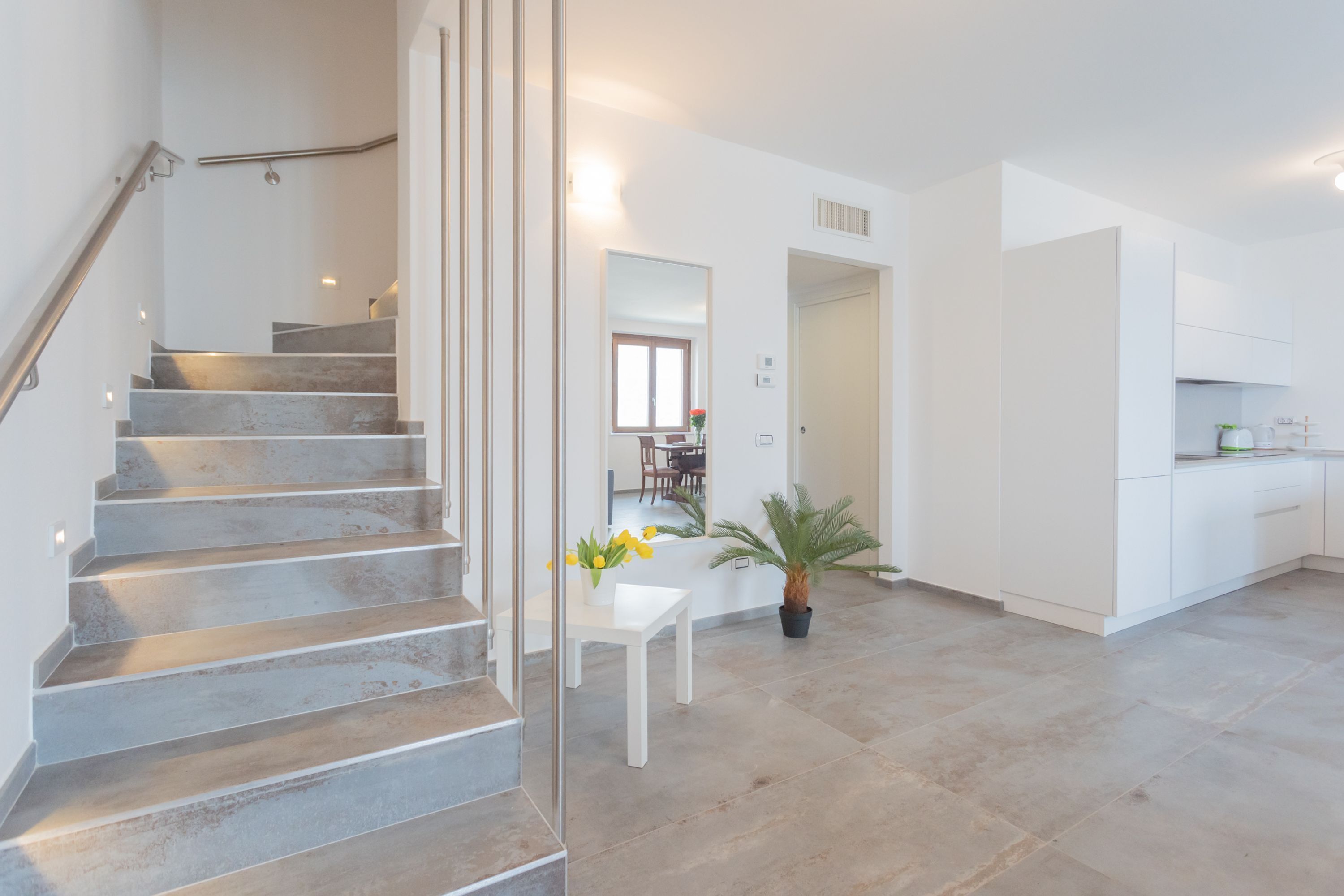 Een modern interieur met een trap, een eethoek en een keuken.