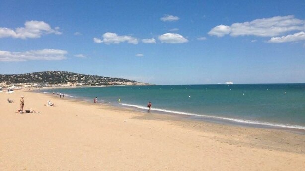 Una playa con cielos despejados y aguas tranquilas.