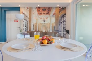 Enjoy a romantic dinner for two in this dining space, complete with a beautifully set table and a stunning abstract art piece.