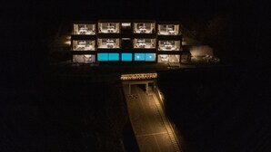 A multi-story hotel with illuminated rooms and a central courtyard. - Valarin Verona Luxory Apartment Wellness (Vercana)