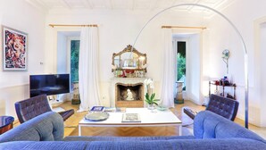 Una sala de estar con chimenea, televisor y dos sofás.
