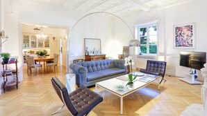 Un salón amplio con sofá, sillones, mesa de centro y televisor.