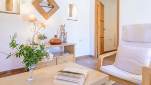 A room with a wooden desk, a white chair, a vase with flowers, and a bookshelf. - Casa de Juanito Viñuela by Ruralidays (Málaga)