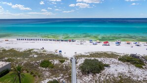 A beach with a clear view of the ocean, a wooden walkway, and beach umbrellas. - Comfy 1-Bedroom, 2-Bath Condo in Gated Community - Includes 3 Adult Bikes! (Santa Rosa Beach)