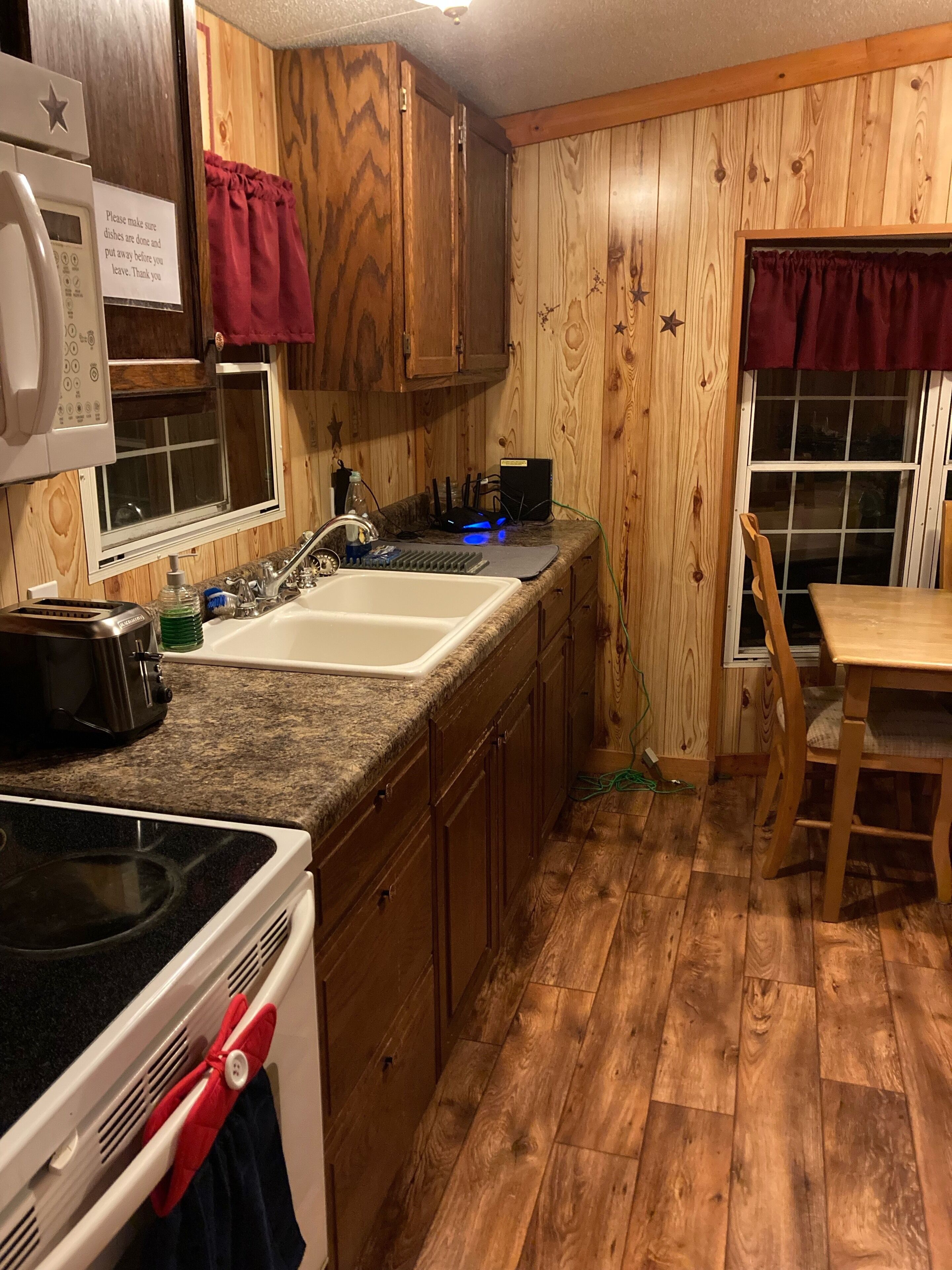 Una cocina con armarios de madera, microondas, tostadora, lavabo y estufa.