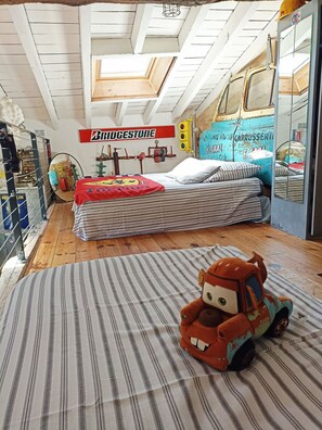 Une pièce avec un lit, une voiture jouet et un panneau Bridgestone.
