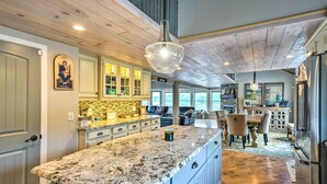 A spacious kitchen with a large marble island, wooden ceiling, and a dining area with a chandelier. - Stunning Enfield Home w/ Deck & Boat Dock! (Enfield)
