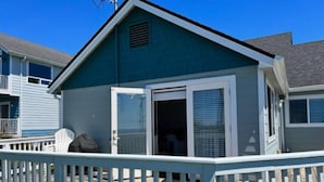 Un bâtiment d’un seul étage, à l’extérieur d’un bleu foncé, avec une porte blanche et une petite fenêtre.