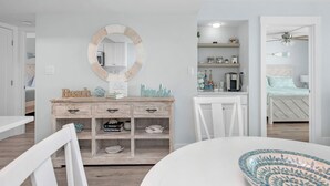 A modern bedroom with a bed, a dresser, a mirror, and a desk with shelves. - Beachcrest Gulf-Front Private Beach- Chair & umbrella service -March-Oct (Santa Rosa Beach)