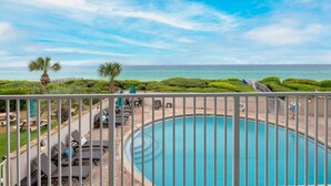 A pool area with lounge chairs and a view of the ocean. - Beachcrest Gulf-Front Private Beach- Chair & umbrella service -March-Oct (Santa Rosa Beach)