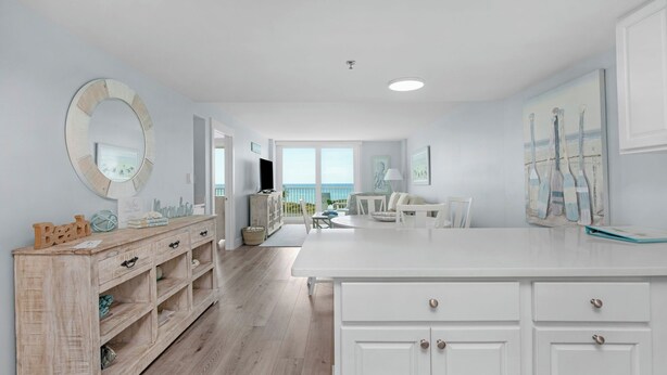 A spacious kitchen with white cabinetry, a wooden sideboard, and a large island. - Beachcrest Gulf-Front Private Beach- Chair & umbrella service -March-Oct (Santa Rosa Beach)