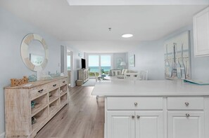 Une cuisine spacieuse avec des meubles blancs, un buffet en bois et un grand îlot central.