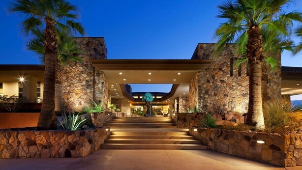 A hotel entrance with a stone facade, palm trees, and a staircase leading to the lobby. - Westin Desert Willow Resort (Palm Desert)