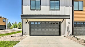 A modern two-story house with a garage, a driveway, and a well-maintained lawn. - Gorgeous Greeley Getaway - Close to Parks! (Greeley)