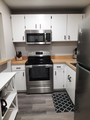 Enjoy cooking in this kitchen with a microwave, oven, sink, and refrigerator.