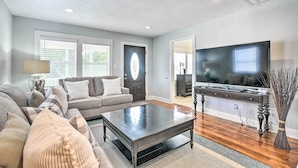 A modern living room with a dark wooden coffee table, a grey sofa with patterned cushions, a flat-screen TV, and a decorative vase. - ~ 1 Mi to Pier & Beaches! Family Home in Galveston (Galveston)