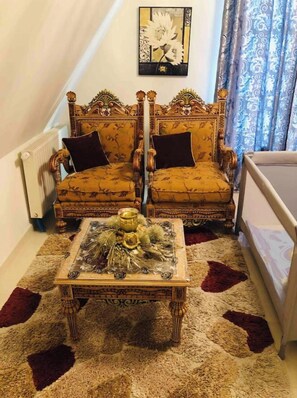 Classic design room with a wooden bed, upholstered chairs, and a small table.