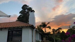 A house with a white exterior, a tiled roof, and a chimney.