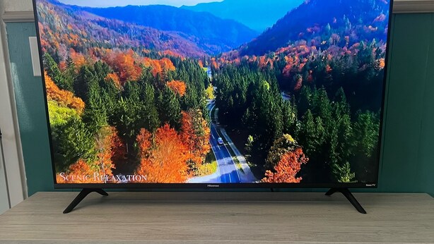 Un televisore a schermo piatto su un mobile in legno con un camino sottostante.