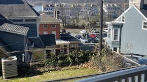 A residential area with houses, a parking lot, and a body of water in the background. - Quarry Landing - Center of Town & River View - 3 Bedroom (Port Deposit)
