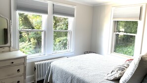 A bedroom with a bed, dresser, and two windows with blinds. - Quarry Landing - Center of Town & River View - 3 Bedroom (Port Deposit)