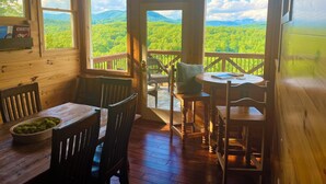 A wooden cabin with a dining area and a balcony overlooking a forested landscape. - Big Mountain Views,  Minutes to Wineries, Hot Tub (Dahlonega)