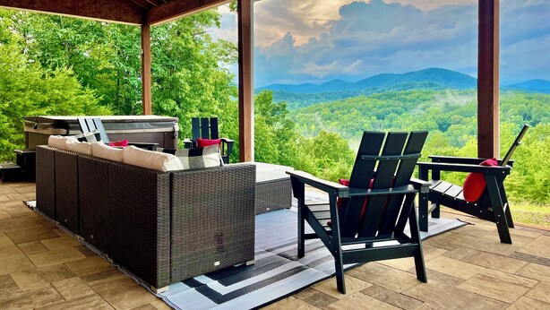 A covered outdoor seating area with a sofa and chairs, a grill, and a view of a mountainous landscape. - Big Mountain Views,  Minutes to Wineries, Hot Tub (Dahlonega)