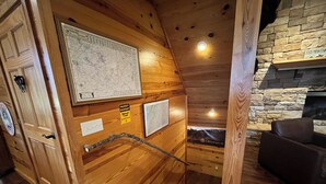 A wooden interior with a map, a fireplace, and a sign indicating a property boundary. - Big Mountain Views,  Minutes to Wineries, Hot Tub (Dahlonega)