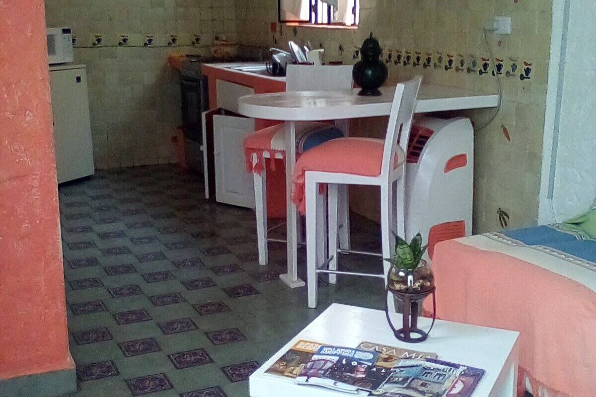 Um espaço de estar compacto com cozinha, área de refeições e um pequeno espaço para sentar.