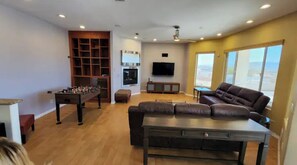 Relax in this inviting living room with a comfortable sofa, flat-screen TV, and foosball table.