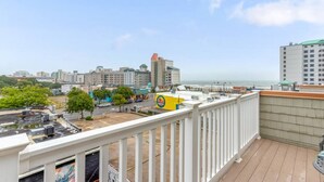 A balcony with a view of a cityscape, including buildings and a beach.