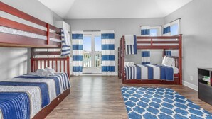 A bedroom with bunk beds, a large window, and a view of the outdoors.