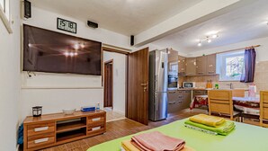 A modern kitchen with wooden cabinets, a stainless steel refrigerator, and a dining area with a table and chairs. - S 2 - modern studio, just 50m from the beach (Korcula)