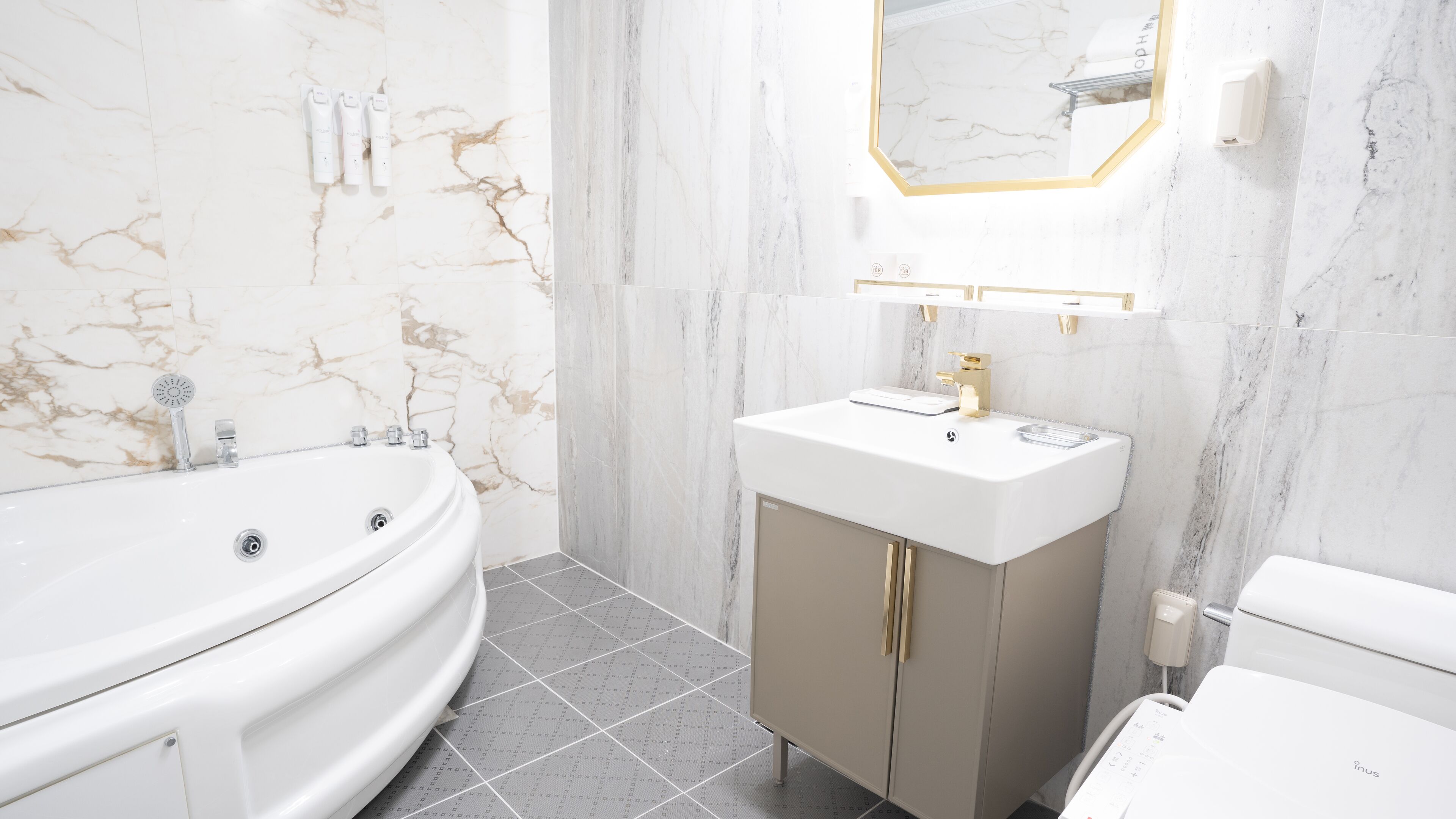 Une salle de bain moderne avec une baignoire sur pieds, un meuble-lavabo avec un miroir et des toilettes.
