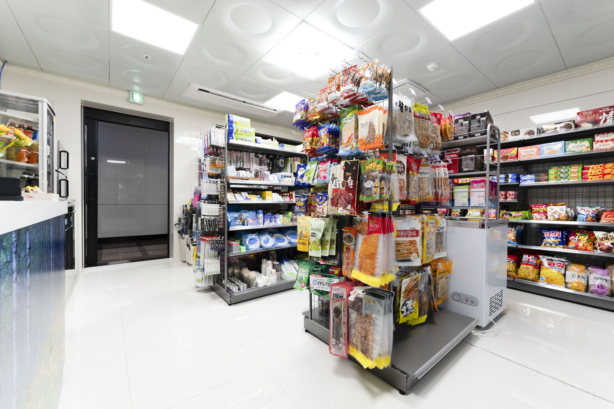 Een supermarkt met schappen vol diverse etenswaren en een koelvitrine.