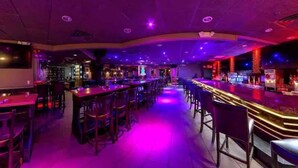 A bar area with multiple seating arrangements and a counter. - Stylish King 1BR Near MetLife & NYC (Elizabeth)
