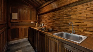 Una cocina con armarios de madera, estufa integrada y pileta de acero inoxidable.