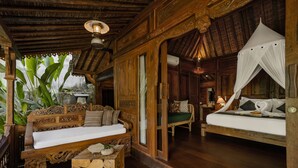 Una habitación de madera con una cama, un banco y una pequeña mesa.