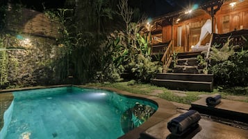 Una piscina al aire libre, tumbonas