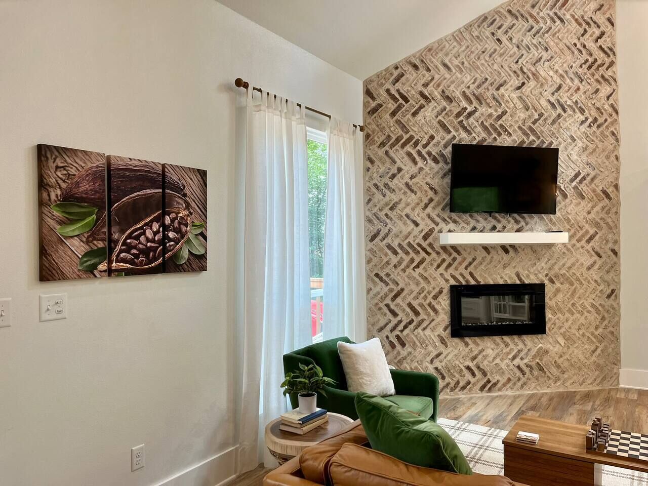 Un salon avec un canapé vert, un téléviseur à écran plat, une cheminée et une table basse.