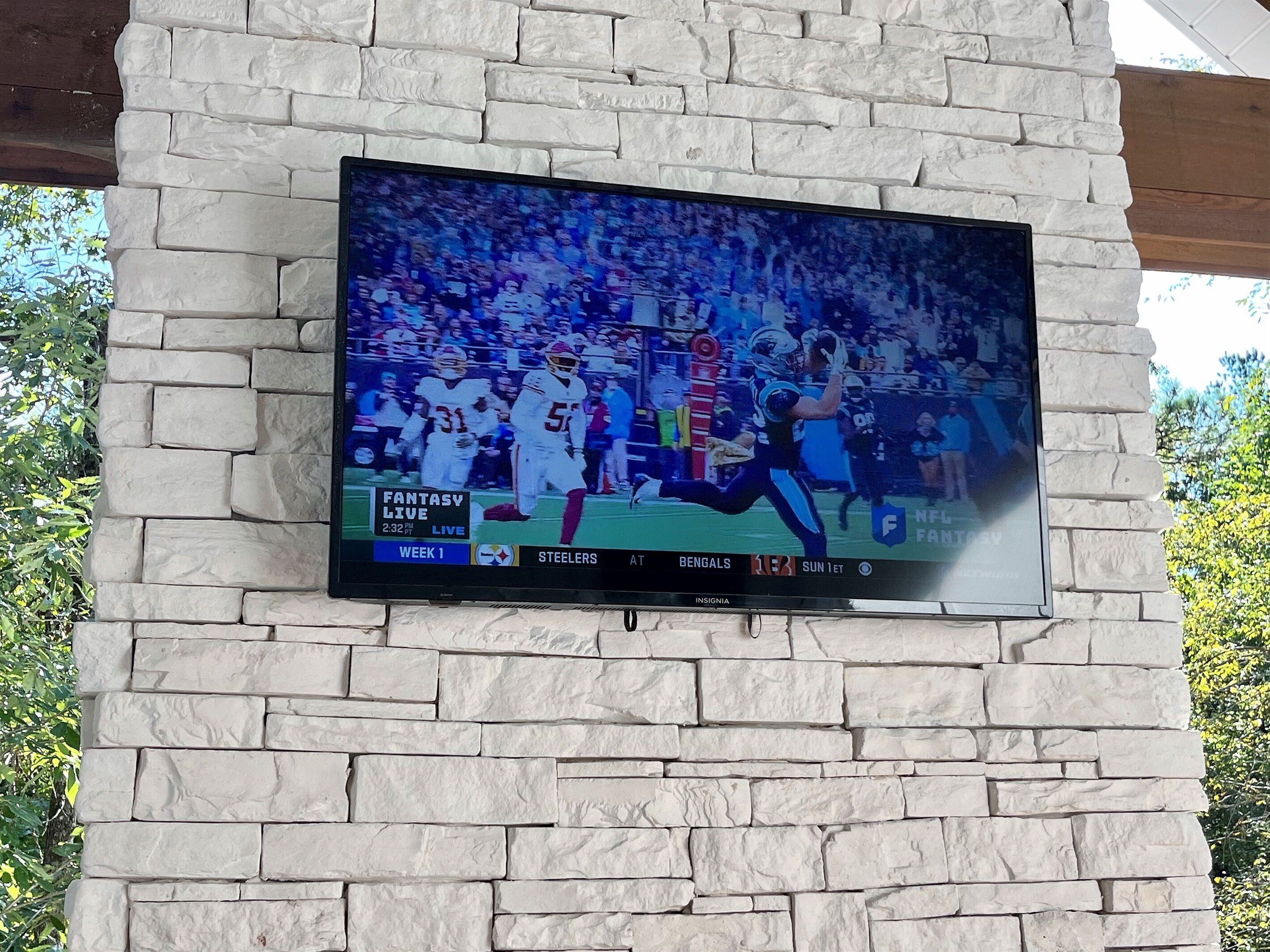 Un televisor de pantalla plana montado en una pared de piedra.