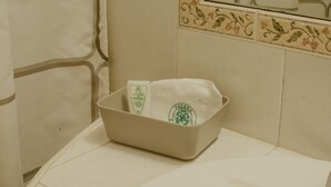 A bathroom with a beige sink, a towel, and a soap dispenser. - Hotel Posada San Agustin (Durango)